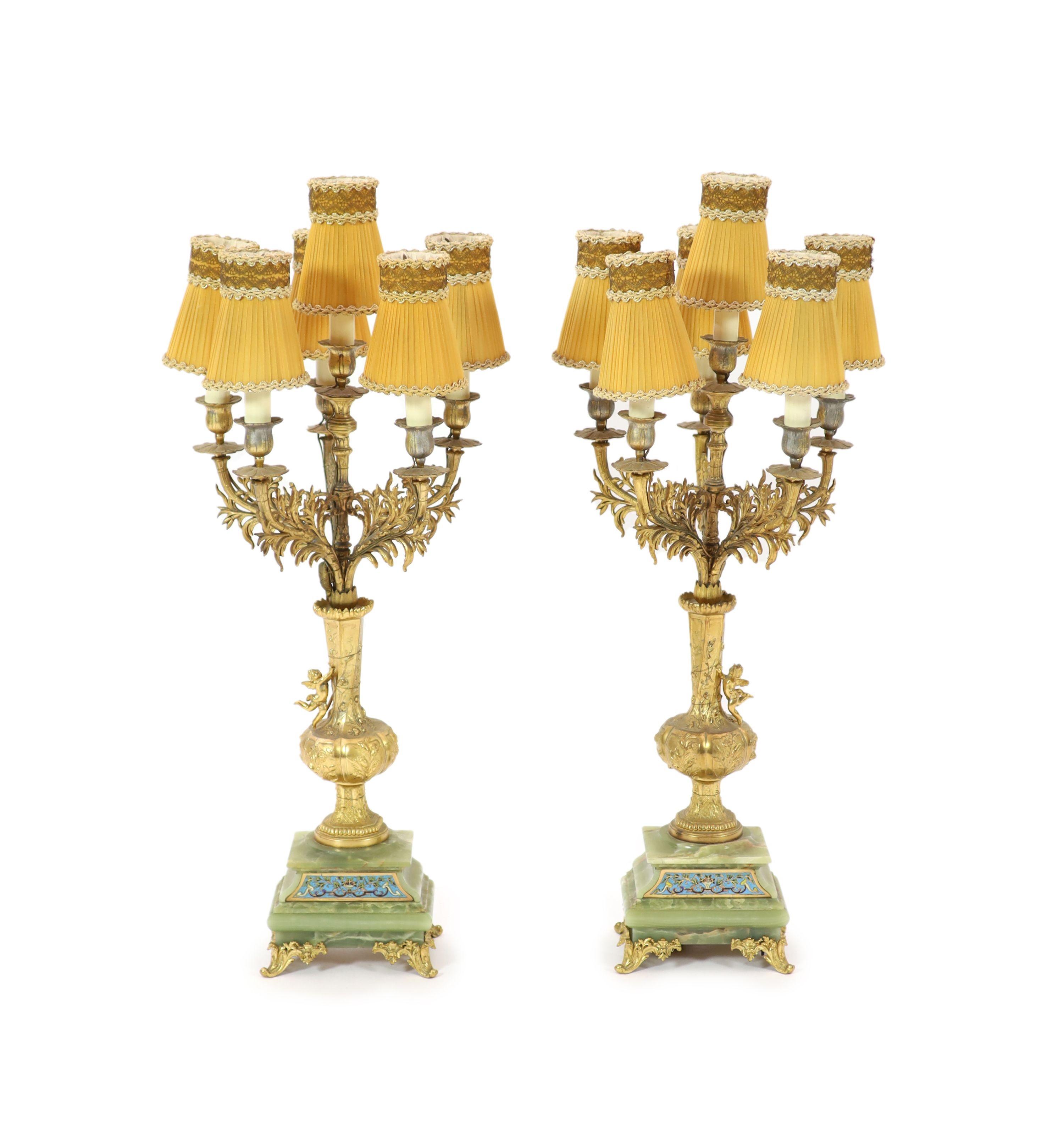 A pair of elaborate gilt metal and green onyx six-light candelabra table lamps on pedestal urn supports incorporating champlevé enamel plaques H 70cm.